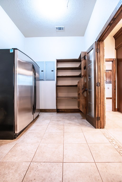 walk in closet featuring light tile patterned floors and electric panel