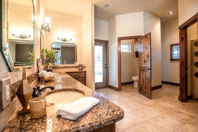 bathroom featuring tile patterned flooring, toilet, and vanity