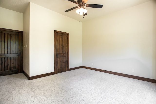 unfurnished room with ceiling fan and carpet