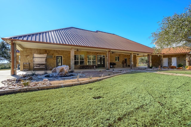 back of house featuring ceiling fan and a yard