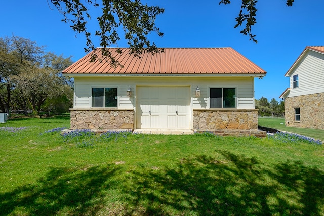 rear view of house featuring a garage and a yard