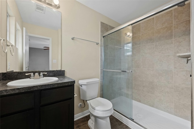 bathroom with toilet, a shower with door, and vanity