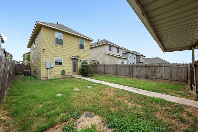 back of house featuring a yard and central AC unit