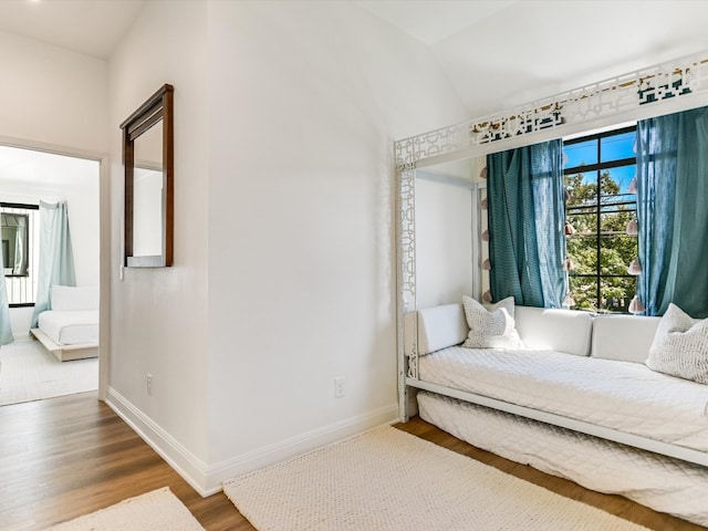 bedroom with vaulted ceiling and hardwood / wood-style flooring