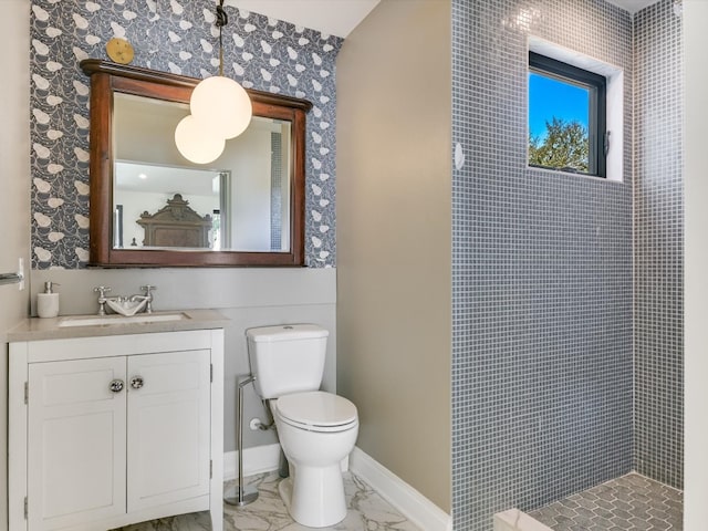 bathroom featuring tiled shower, vanity, and toilet