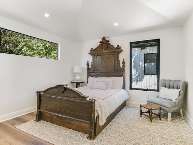 bedroom featuring lofted ceiling and light hardwood / wood-style flooring