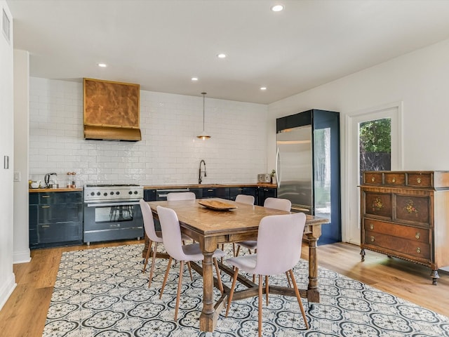 dining space with light wood-type flooring and sink