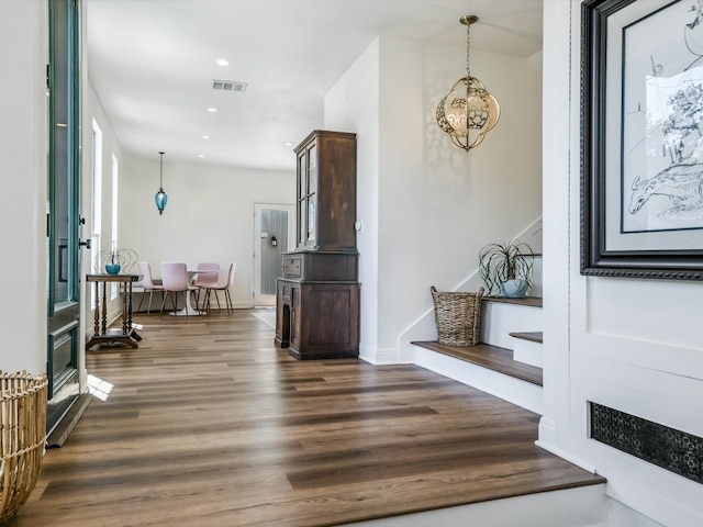 foyer entrance featuring dark hardwood / wood-style floors and a notable chandelier