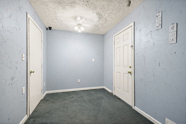 carpeted foyer entrance featuring a textured ceiling and ceiling fan