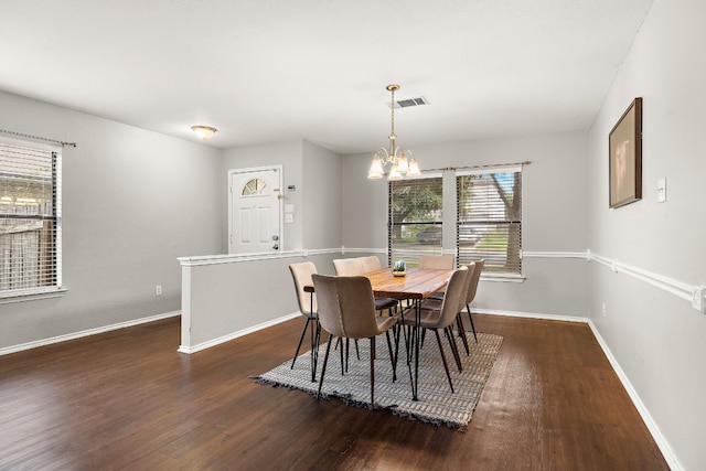 dining room featuring dark wood-type flooring and a notable chandelier