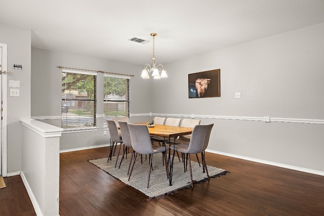 dining space with dark hardwood / wood-style flooring and a notable chandelier