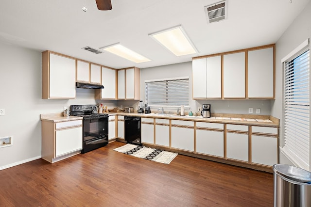 kitchen with black appliances and white cabinetry