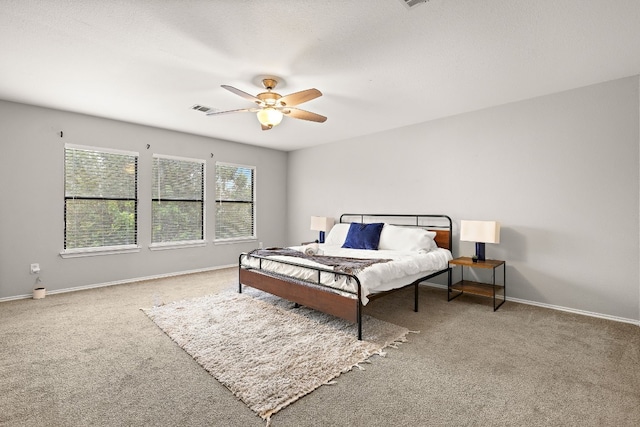 carpeted bedroom featuring ceiling fan and a textured ceiling