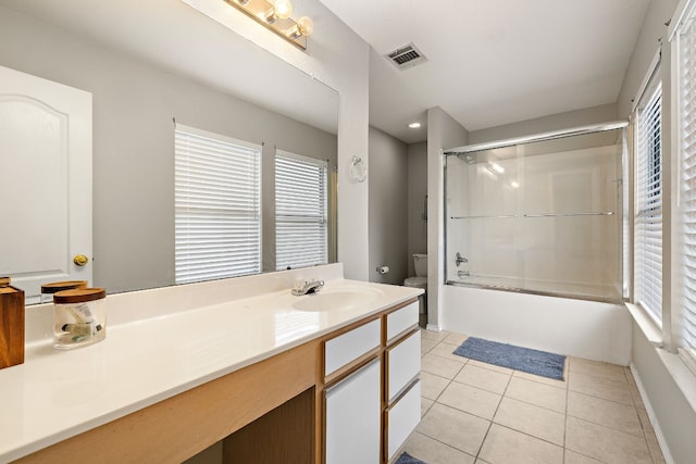 full bathroom featuring a wealth of natural light, vanity, toilet, and shower / bath combination with glass door