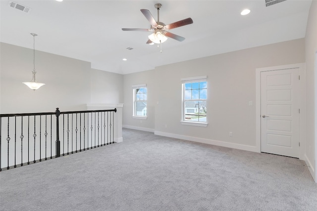 unfurnished room with light colored carpet and ceiling fan