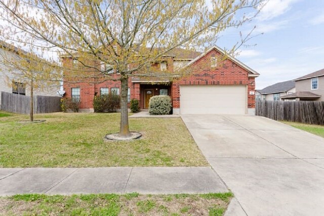 view of property featuring a garage and a front yard