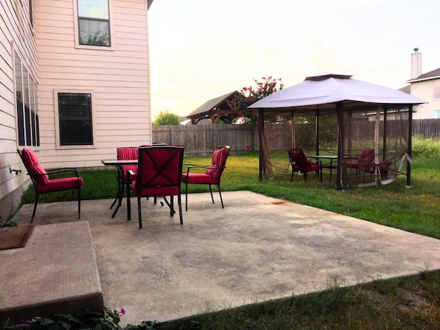 patio terrace at dusk with a yard and a gazebo