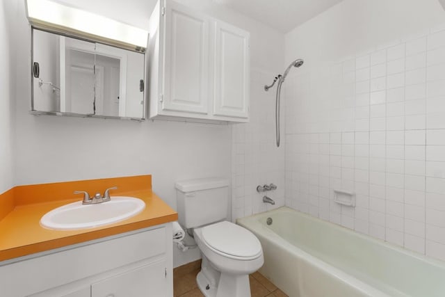 full bathroom with tile patterned floors, tiled shower / bath, toilet, and vanity