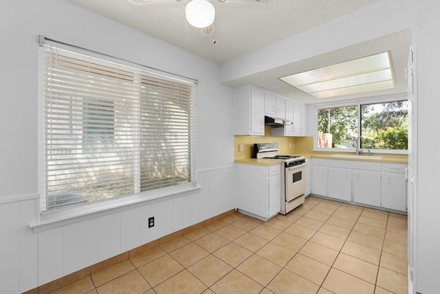 kitchen featuring white gas range, a textured ceiling, sink, ceiling fan, and white cabinets