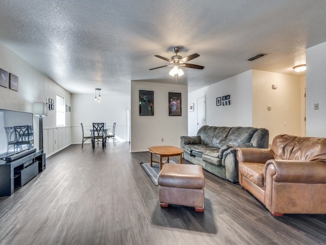 living room with hardwood / wood-style floors, a textured ceiling, and ceiling fan