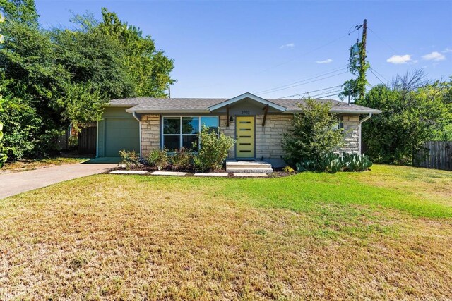 ranch-style house featuring a front lawn and a garage