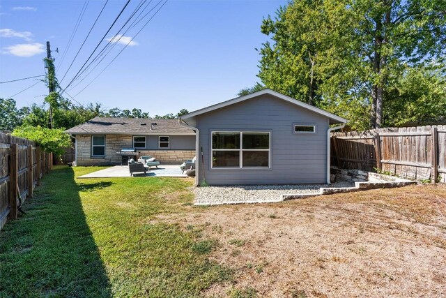 back of property with a patio area and a lawn