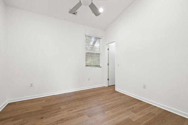 spare room with ceiling fan, lofted ceiling, and light hardwood / wood-style flooring