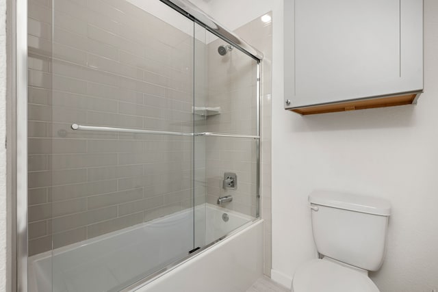 bathroom featuring toilet and combined bath / shower with glass door