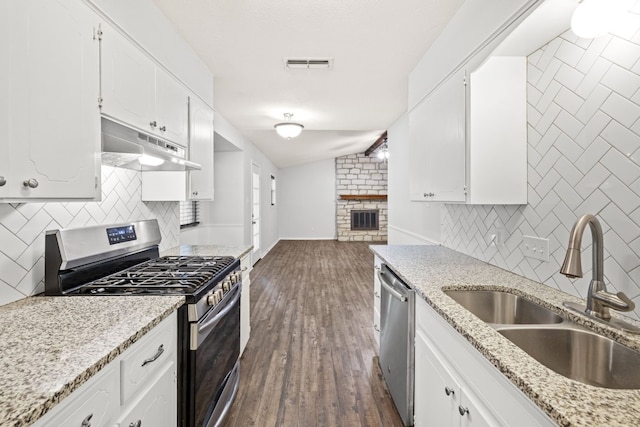 kitchen featuring appliances with stainless steel finishes, dark hardwood / wood-style flooring, white cabinetry, sink, and lofted ceiling