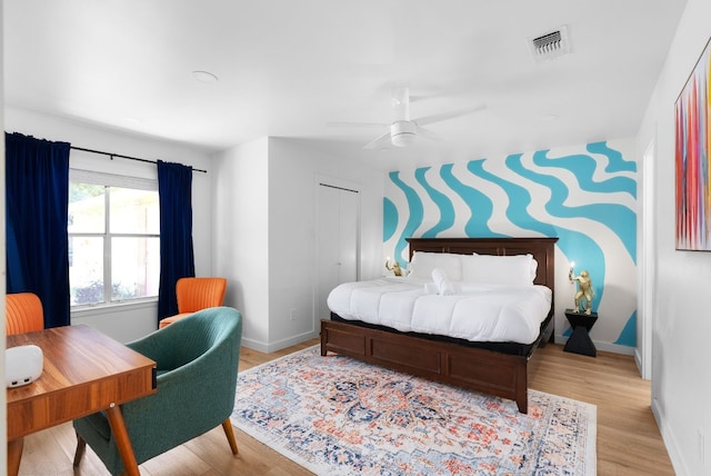 bedroom featuring ceiling fan, a closet, and light wood-type flooring