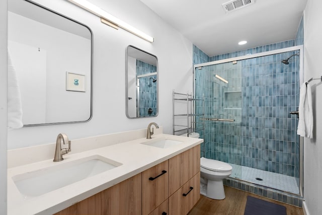 bathroom with vanity, toilet, hardwood / wood-style floors, and an enclosed shower