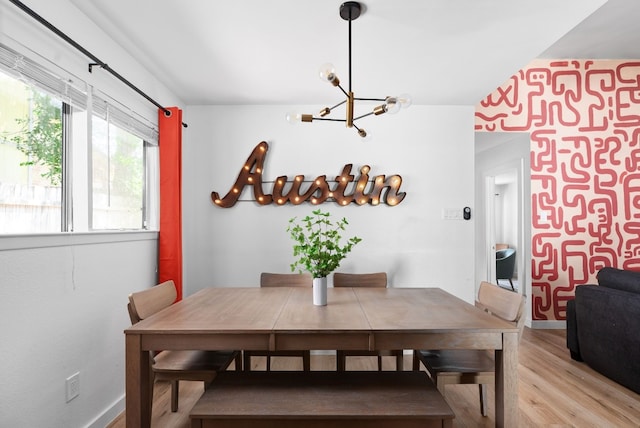 dining space featuring light hardwood / wood-style floors and a notable chandelier