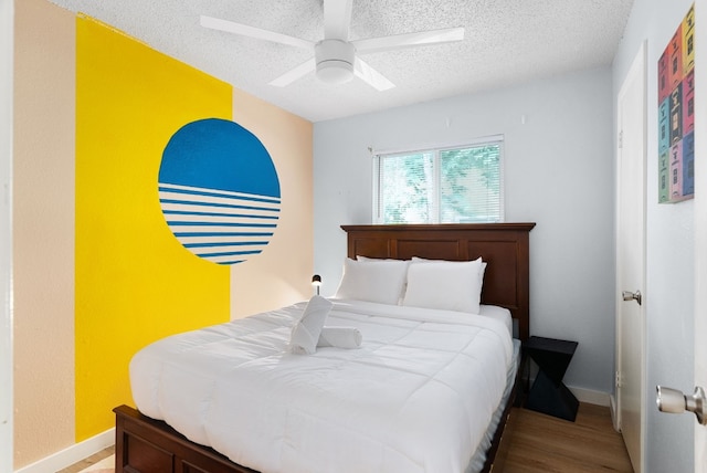 bedroom featuring ceiling fan, hardwood / wood-style flooring, and a textured ceiling