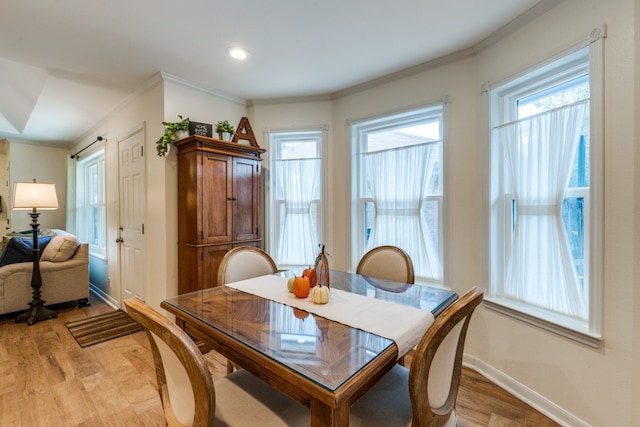 dining room featuring crown molding and light hardwood / wood-style flooring