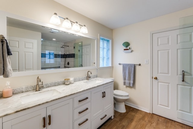 bathroom featuring vanity, toilet, wood-type flooring, and a shower with door