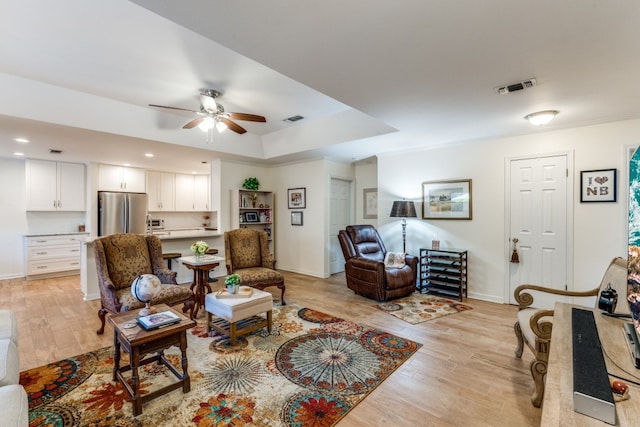 living room with ceiling fan and light hardwood / wood-style floors