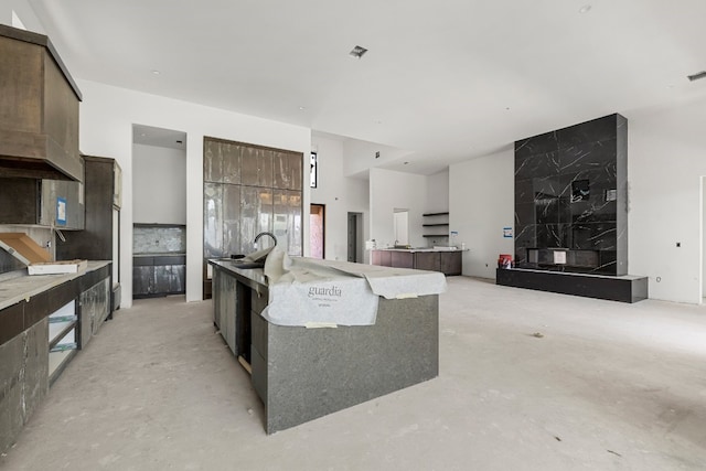 kitchen featuring a kitchen island, sink, and dark brown cabinetry