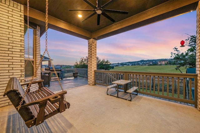 patio terrace at dusk with a deck and ceiling fan