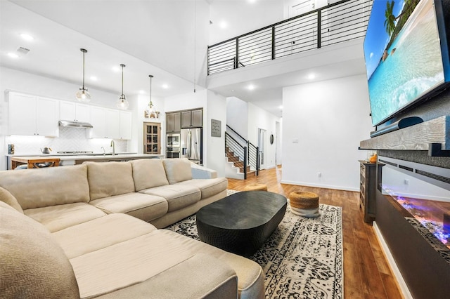 living room with a high ceiling, dark hardwood / wood-style floors, and sink