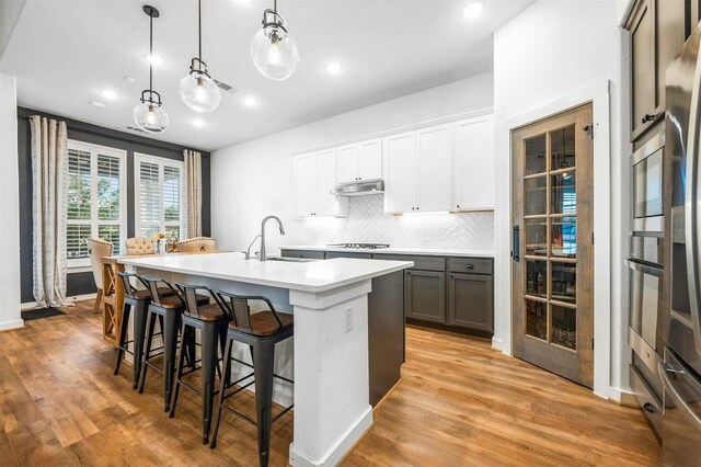 7828 Pace Ravine Dr, Lago Vista, TX 78645 - kitchen featuring sink, appliances with stainless steel finishes, hanging light fixtures, an island with sink, and white cabinets