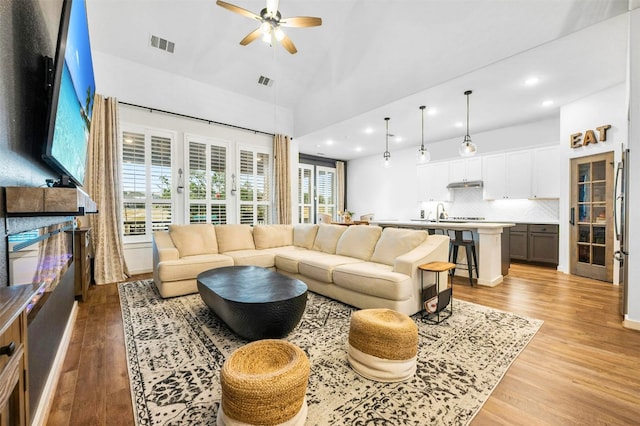 living room with light hardwood / wood-style floors and ceiling fan