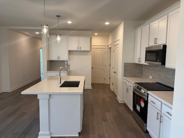 kitchen with appliances with stainless steel finishes, sink, white cabinets, and decorative light fixtures