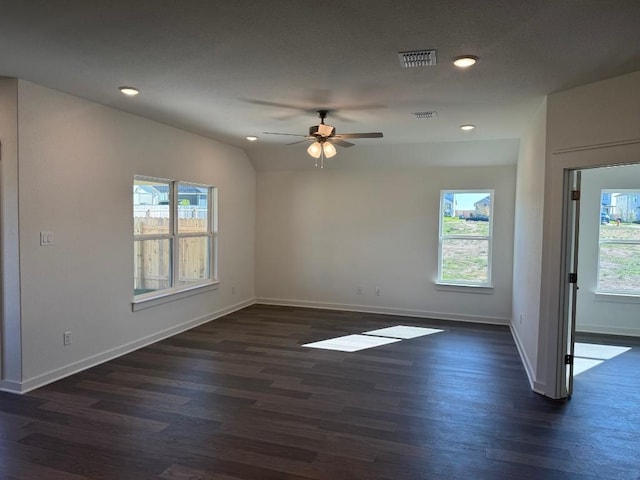 empty room featuring vaulted ceiling, dark hardwood / wood-style floors, and ceiling fan