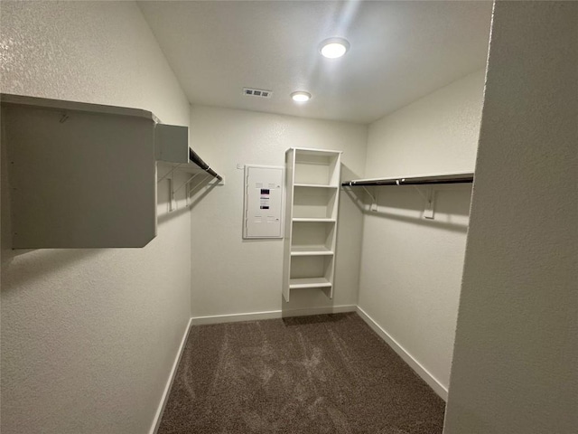 walk in closet with dark colored carpet