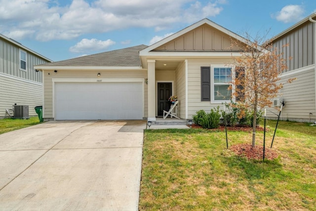 view of front of house with a garage, a front yard, and central air condition unit