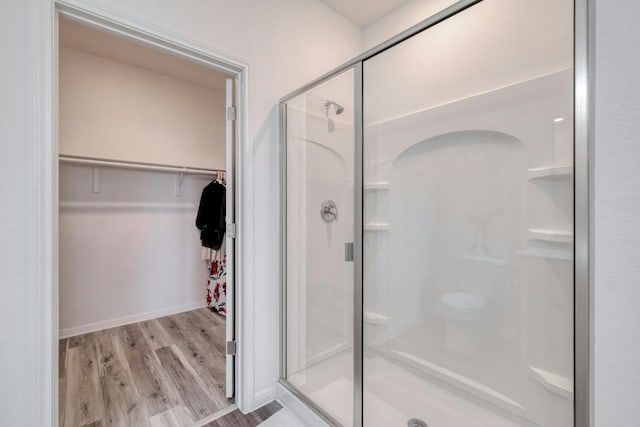 14601 Shooter Mc Gavin Dr, Manor, TX 78653 - bathroom featuring a shower stall, a spacious closet, and wood finished floors