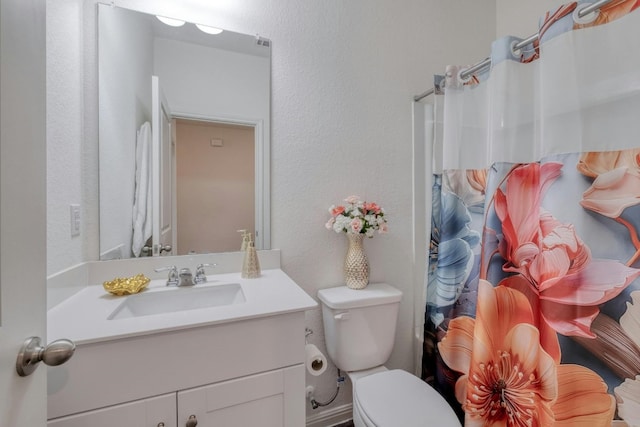 bathroom featuring vanity, toilet, and a shower with shower curtain