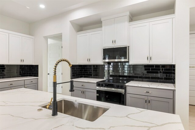 kitchen with white cabinets, appliances with stainless steel finishes, and sink