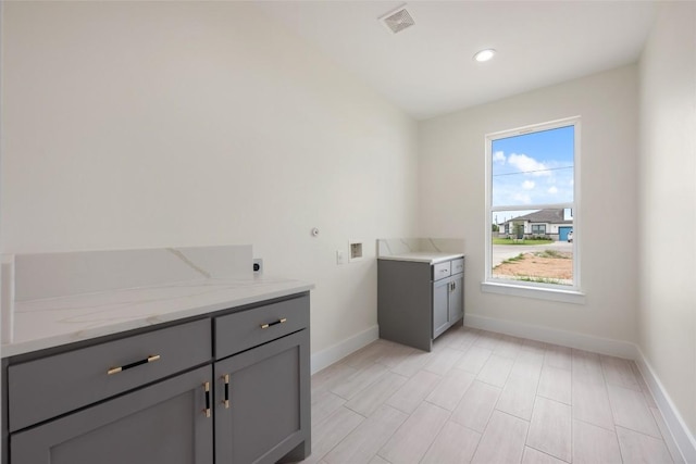 clothes washing area with hookup for an electric dryer, baseboards, visible vents, washer hookup, and cabinet space