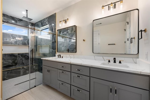 bathroom featuring visible vents, a sink, a marble finish shower, and double vanity
